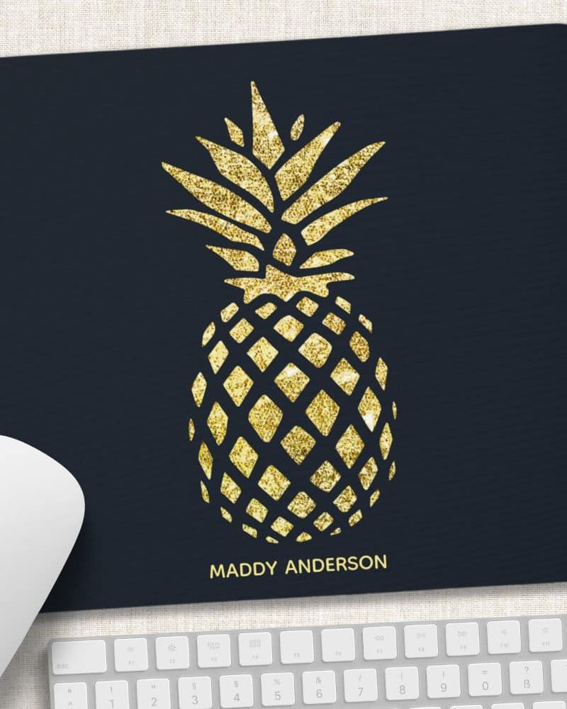 Gold glitter pineapple on a dark blue mousepad with a name at the bottom.