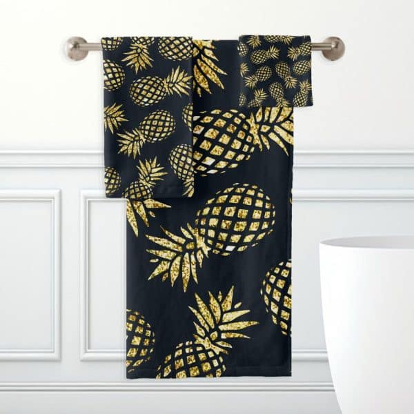 Black Bath Towels With A Gold Glitter Pineapple Pattern.