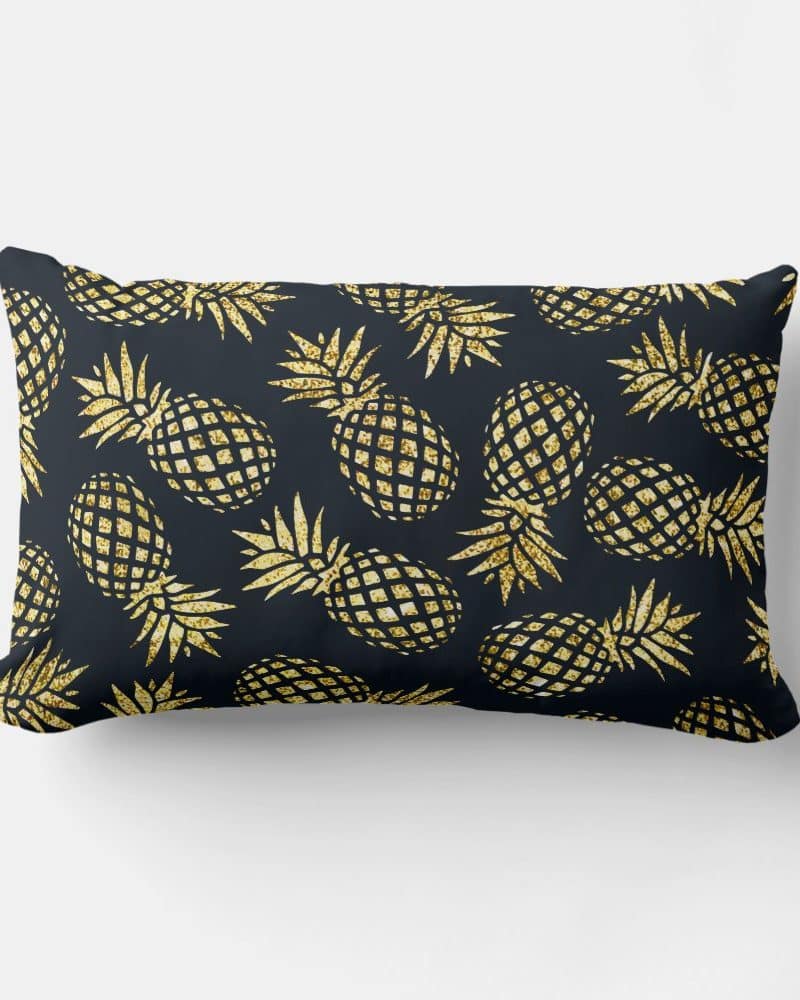 Rectangular throw pillow with a dark background and a repeating pattern of gold glitter pineapples.
