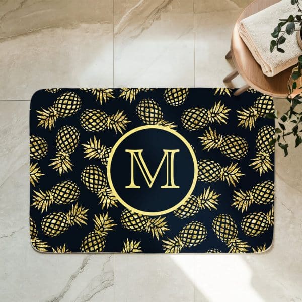 Gold Glitter Pineapples On A Navy Blue Bath Mat With A Gold Monogram M In The Center.