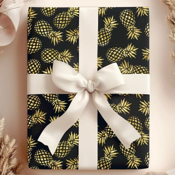 Gift Box With Black Wrapping Paper And A Gold Glitter Pineapple Pattern, Tied With A Cream-Colored Ribbon.