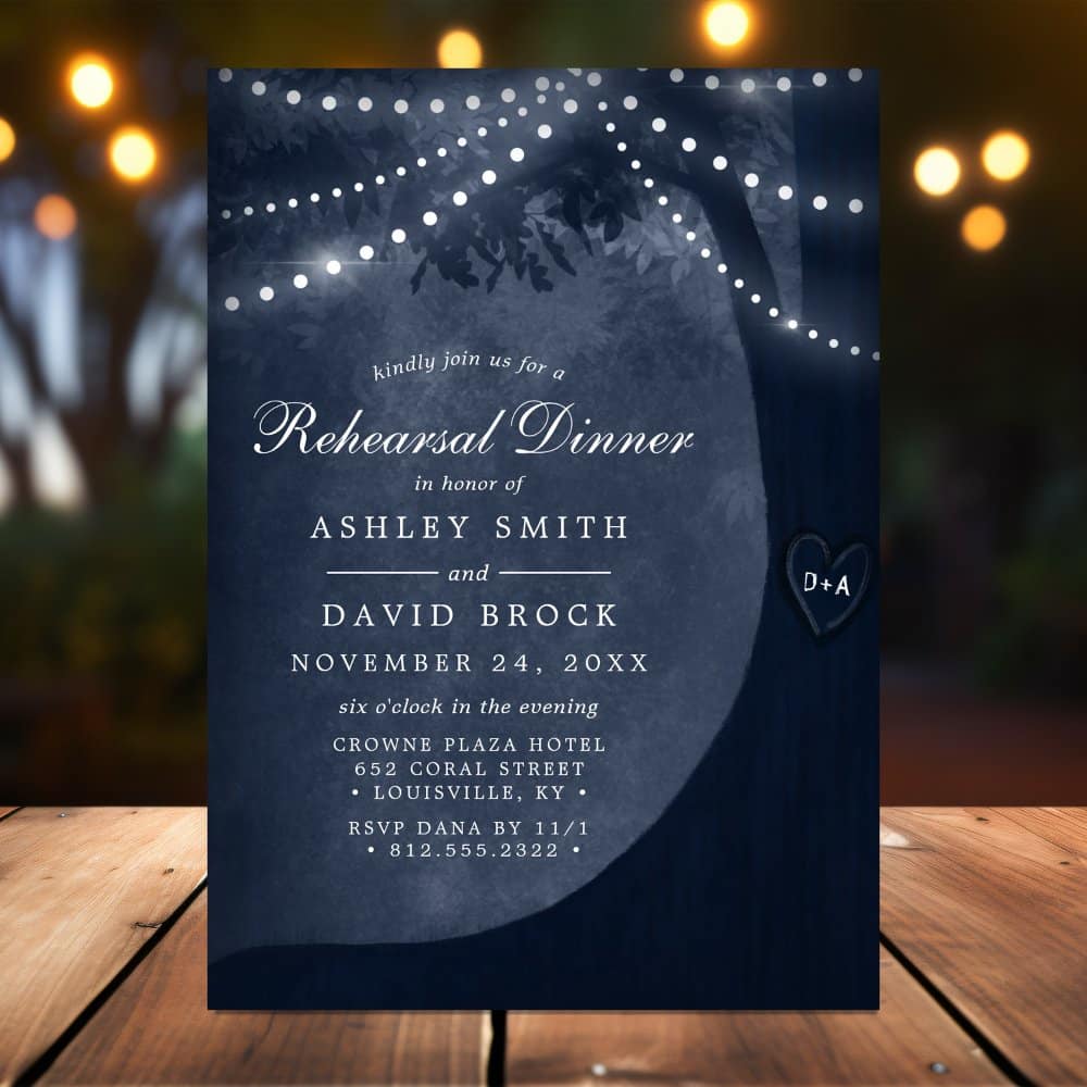 Navy blue rehearsal dinner invitation with a tree silhouette, string lights, and the couple's names.