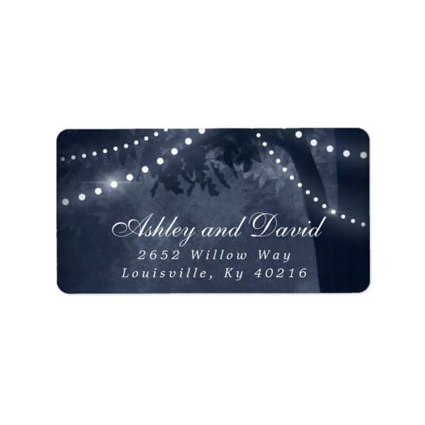Dark Blue Return Address Label With Ashley And David'S Address, Overlaid On A Nighttime Scene Of String Lights On A Tree.