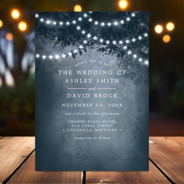 Wedding Invitation With A Dark Blue Background Featuring String Lights Hanging From Tree Branches. The Invitation Announces The Wedding Of Ashley Smith And David Brock.