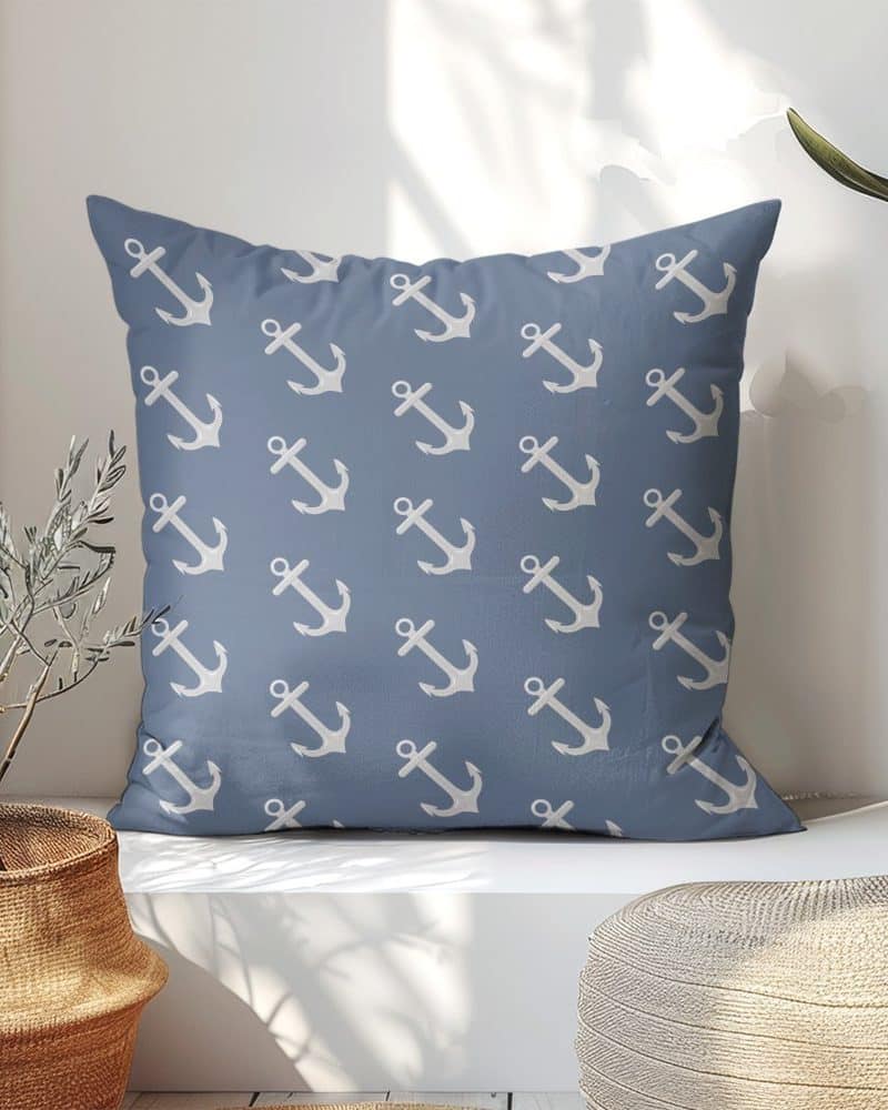 Blue square pillow with a repeating pattern of white anchors.