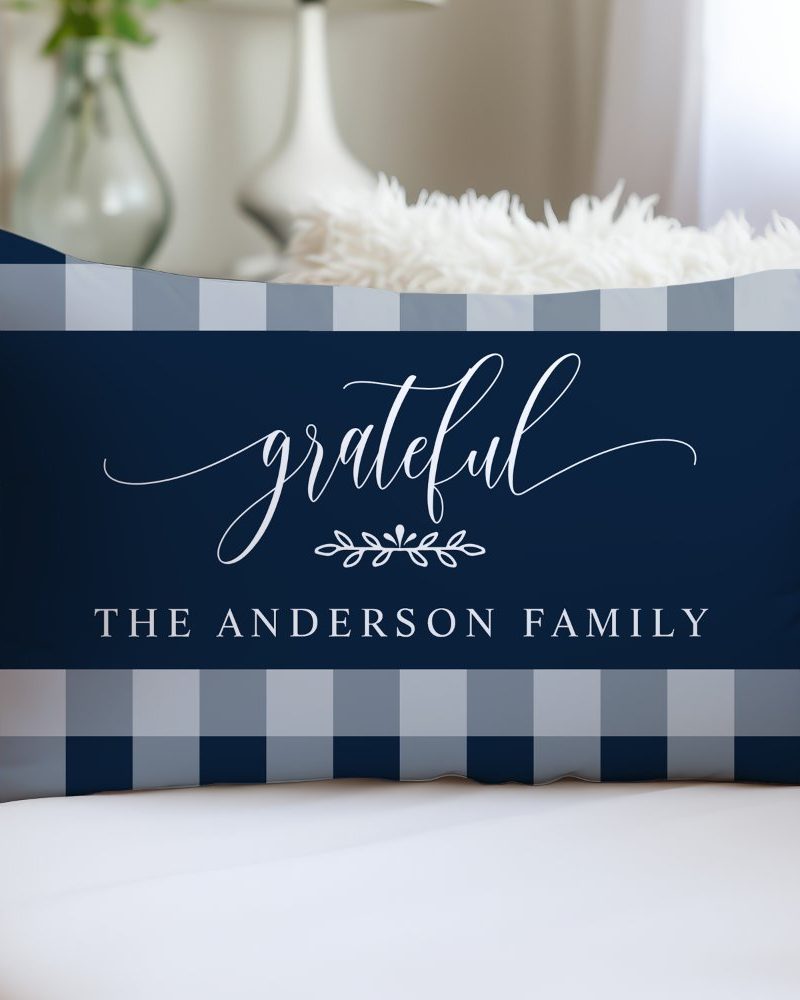Navy blue and gray gingham pillow with the word grateful in elegant script and the Anderson family name.