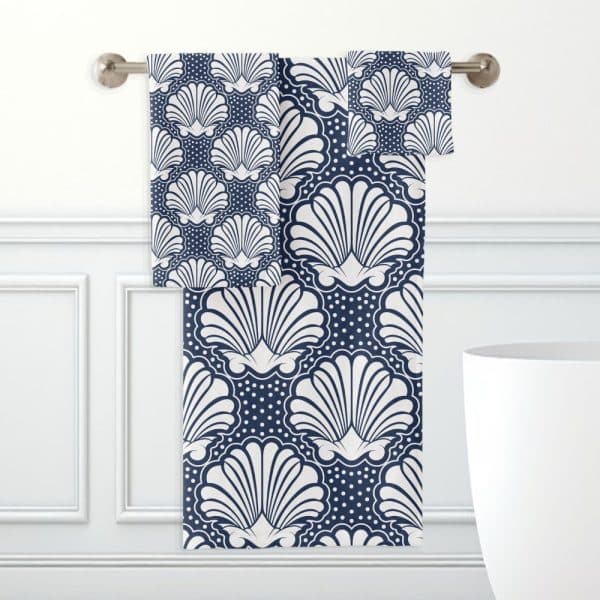Navy Blue And White Hand Towels With A Seashell Pattern Hanging On A Towel Bar.