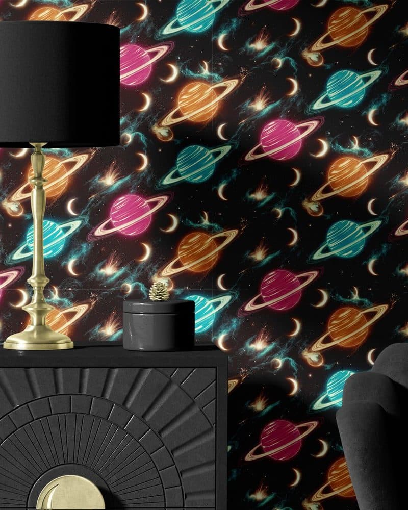 Black dresser with a gold lamp and decorative box against a dark wallpaper featuring a repeating pattern of neon planets and stars.