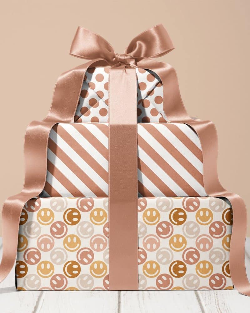 Stack of three gifts with rose gold ribbon.