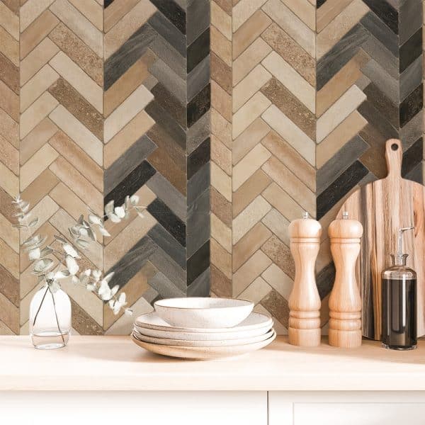 Stack Of Dishes And Kitchen Accessories In Front Of A Herringbone Patterned Backsplash.