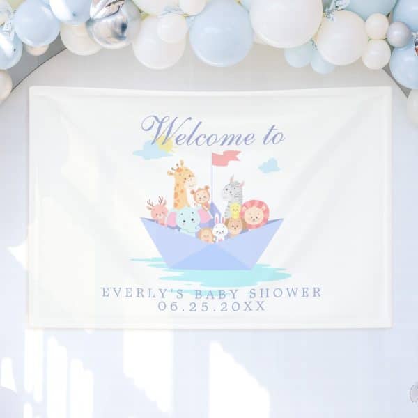 A White Banner Announces Everly'S Baby Shower With The Date, And Features Cartoon Animals On A Paper Boat.