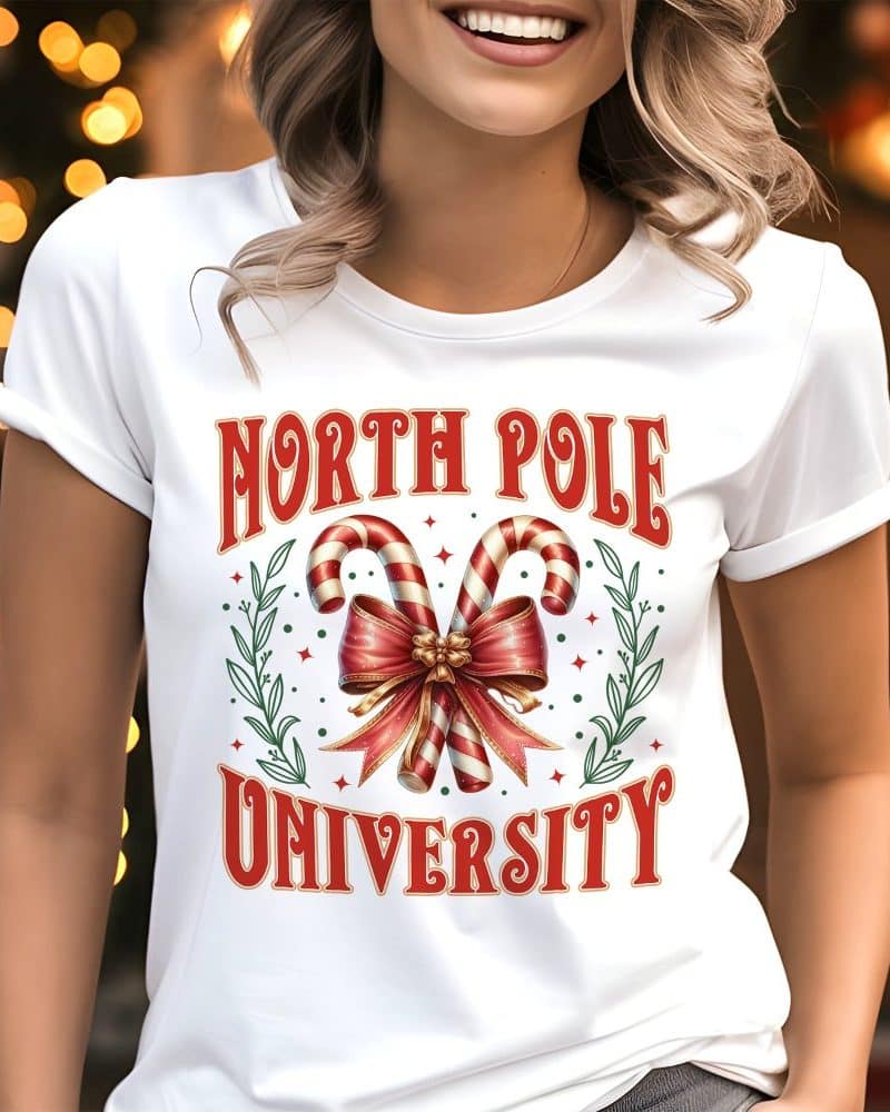 White t-shirt with a North Pole University design featuring candy canes tied with a bow.