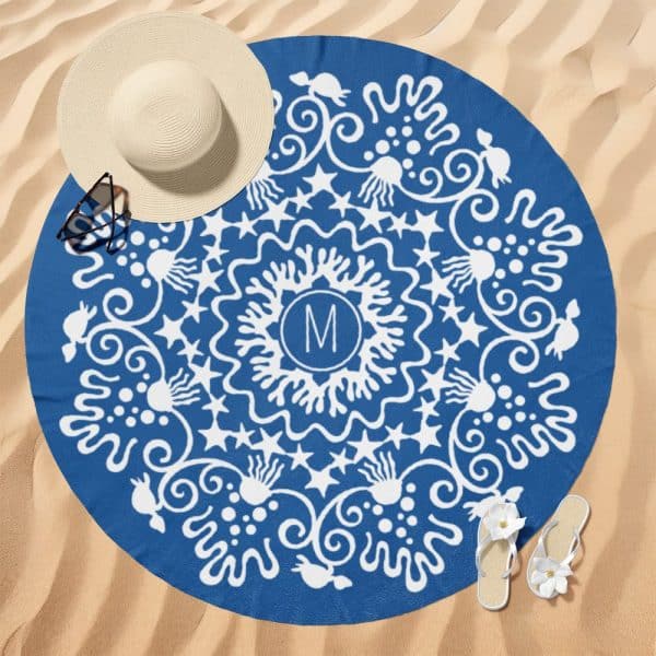 A Blue Round Beach Towel With A White Mandala Design And A Central Monogram.
