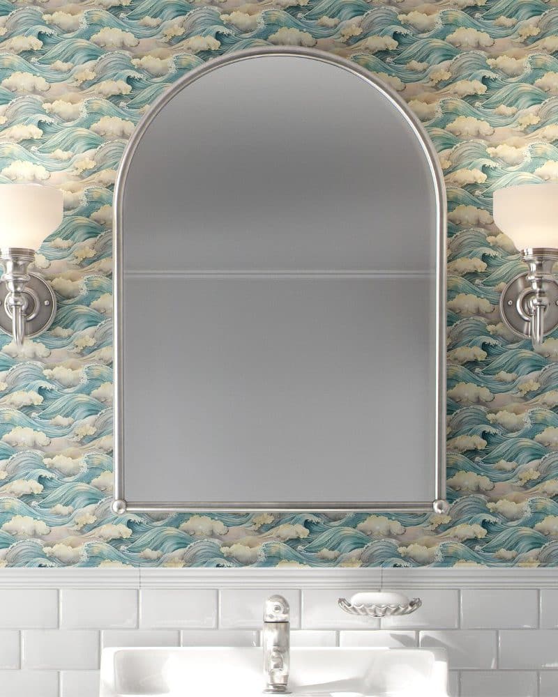 Arch-shaped mirror on a wall with ocean wave wallpaper.