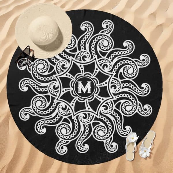 Black Round Beach Towel With A White Mandala Design Featuring An Initial M In The Center.