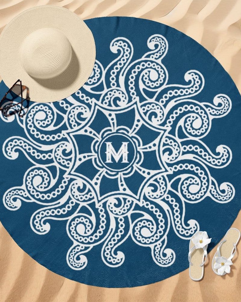 Round beach towel, dark blue with a white mandala design and a monogram.