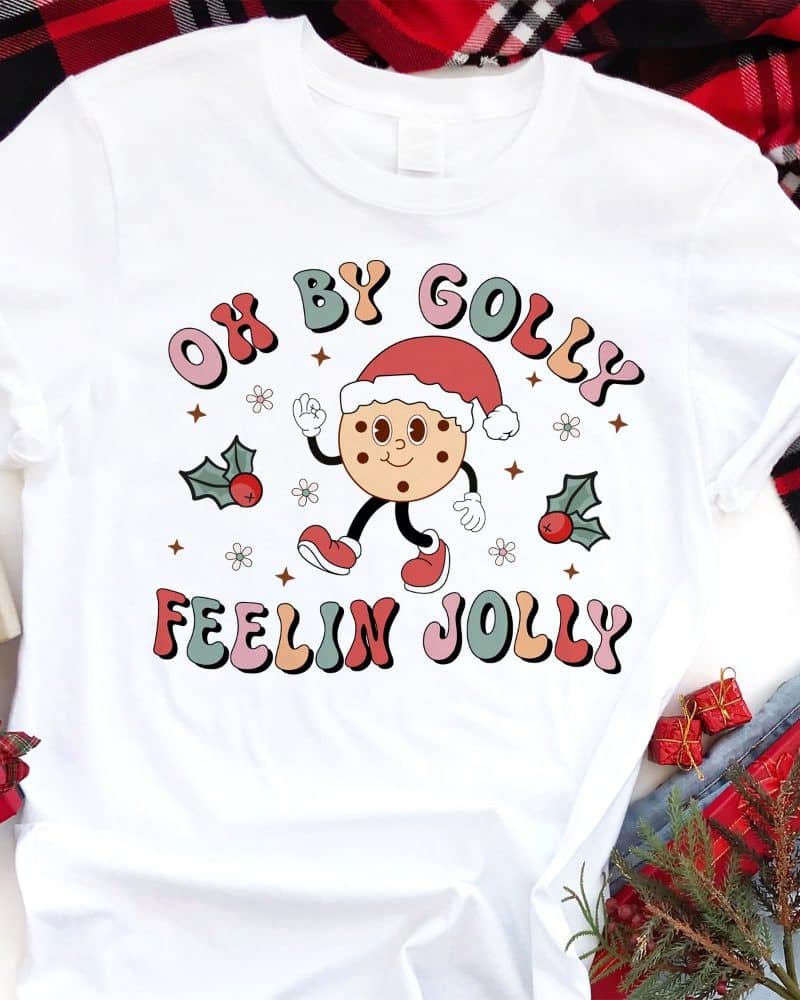 White t-shirt with a Christmas cookie character design that says Oh By Golly Feelin Jolly.