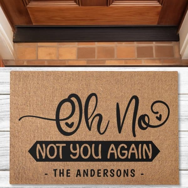 Tan Welcome Mat With Black Lettering That Says Oh No, Not You Again, The Andersons.