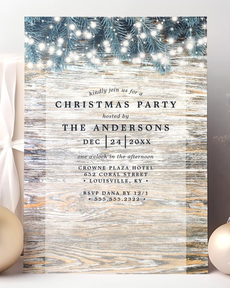 Christmas party invitation featuring a wood background, pine boughs, and sparkling lights.