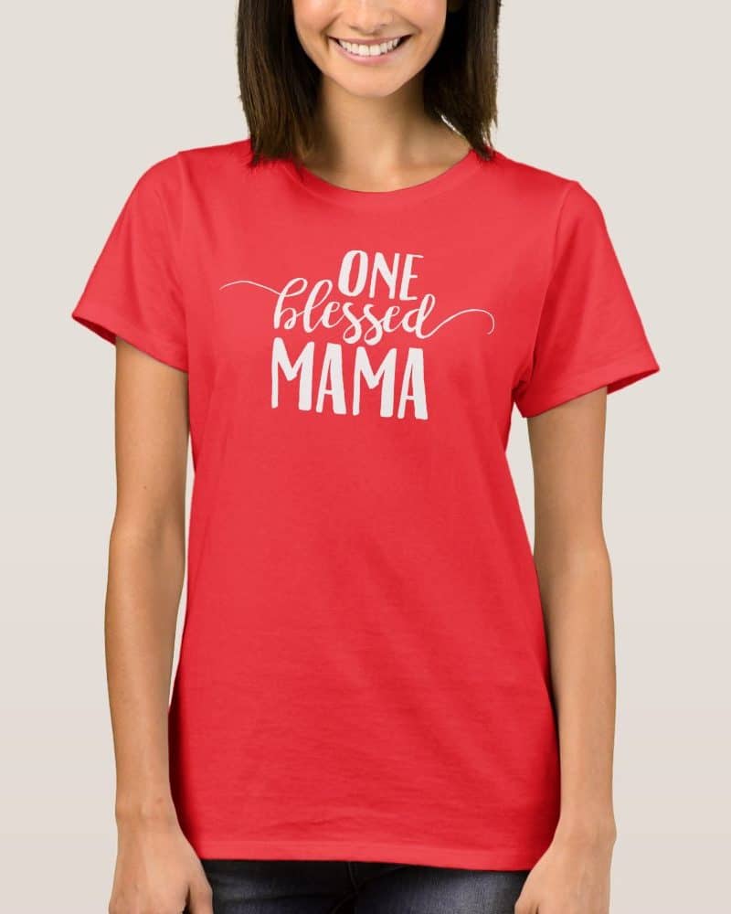 Woman wearing a red t-shirt that says One Blessed Mama in white lettering.
