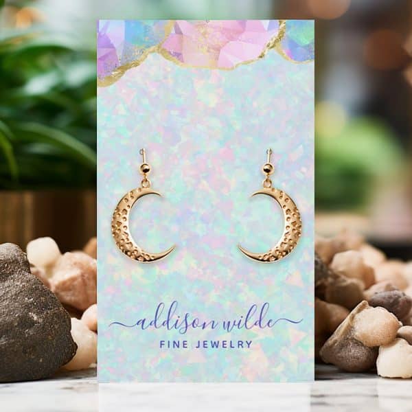 Gold Crescent Moon Earrings Displayed On A Pastel Card.