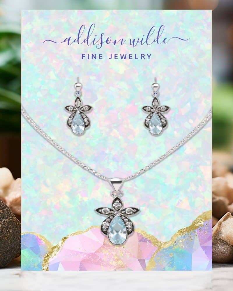 Silver necklace and earrings set with light blue teardrop stones.
