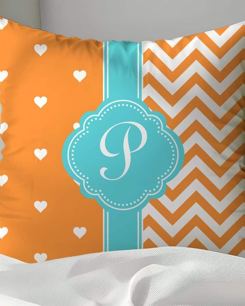Orange and teal pillow with white hearts and chevron pattern, featuring a teal monogram P.