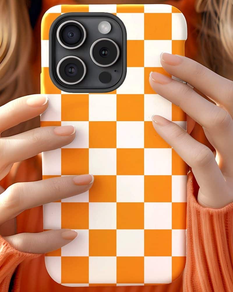 Hands holding an orange and white checkered phone case.