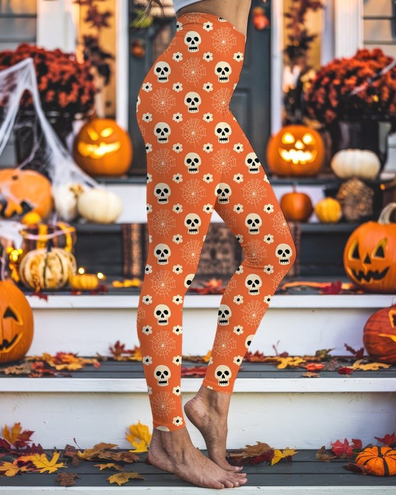 Person's legs wearing orange leggings with a Halloween pattern of skulls and spiderwebs.