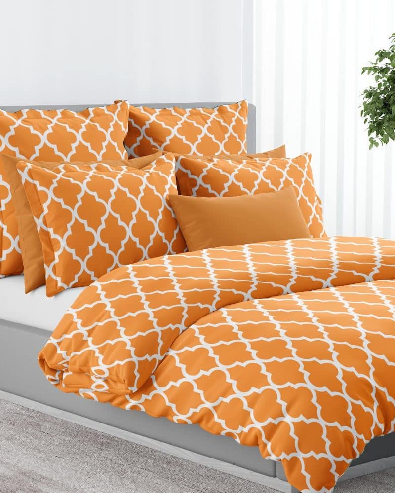 Orange duvet cover and pillows with a white quatrefoil pattern.