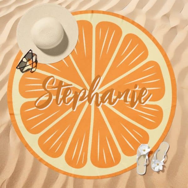 Round Beach Towel With An Orange Slice Design And The Name Stephanie.