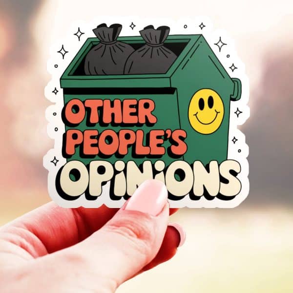 Hand Holding A Sticker Of A Dumpster With Garbage Bags Inside, And The Text &Quot;Other People'S Opinions&Quot; Below It. A Smiley Face Is On The Dumpster.