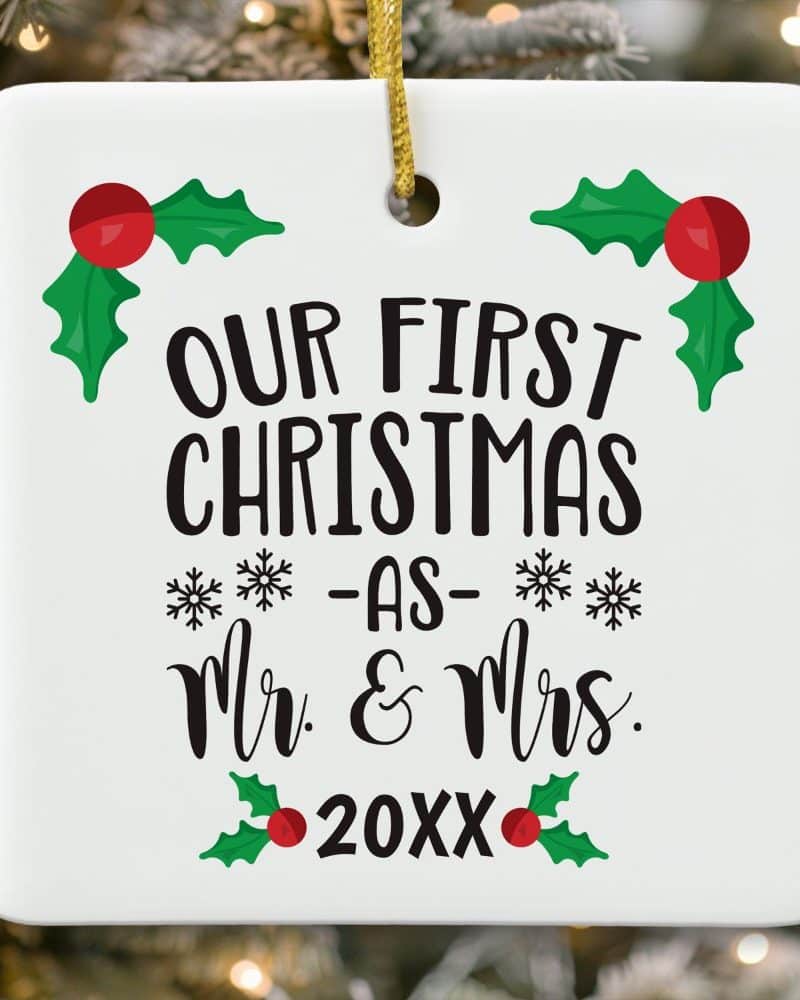 White square Christmas ornament that reads Our First Christmas as Mr. & Mrs. 20XX. Holly leaves and berries decorate the design.