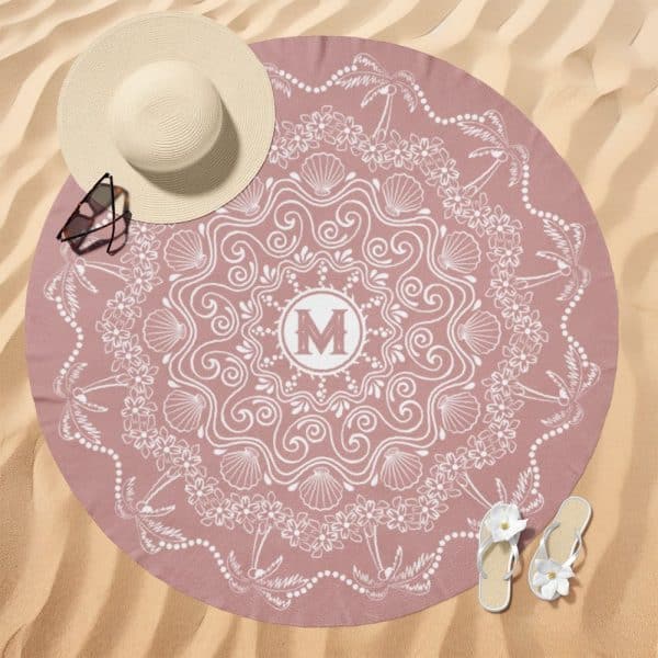 Pink Round Beach Towel With A White Mandala Design, Featuring Palm Trees, Shells, And Flowers; A Monogrammed M Is In The Center.