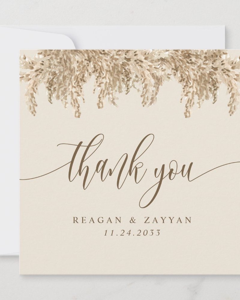 Beige thank you card with a tan pampas grass design at the top and the names Reagan & Zayyan and the date 11.24.2033 below the text.