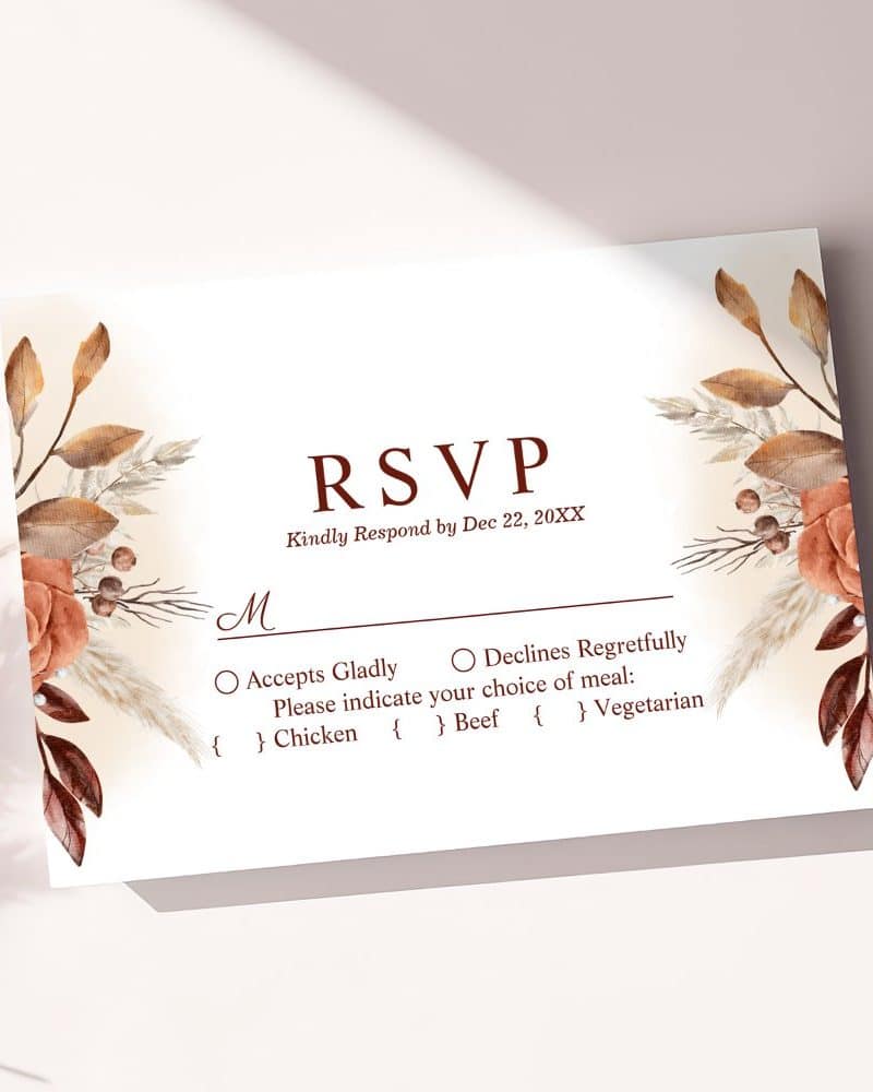 An RSVP card with autumnal floral design, requesting a response by December 22nd and meal choice.