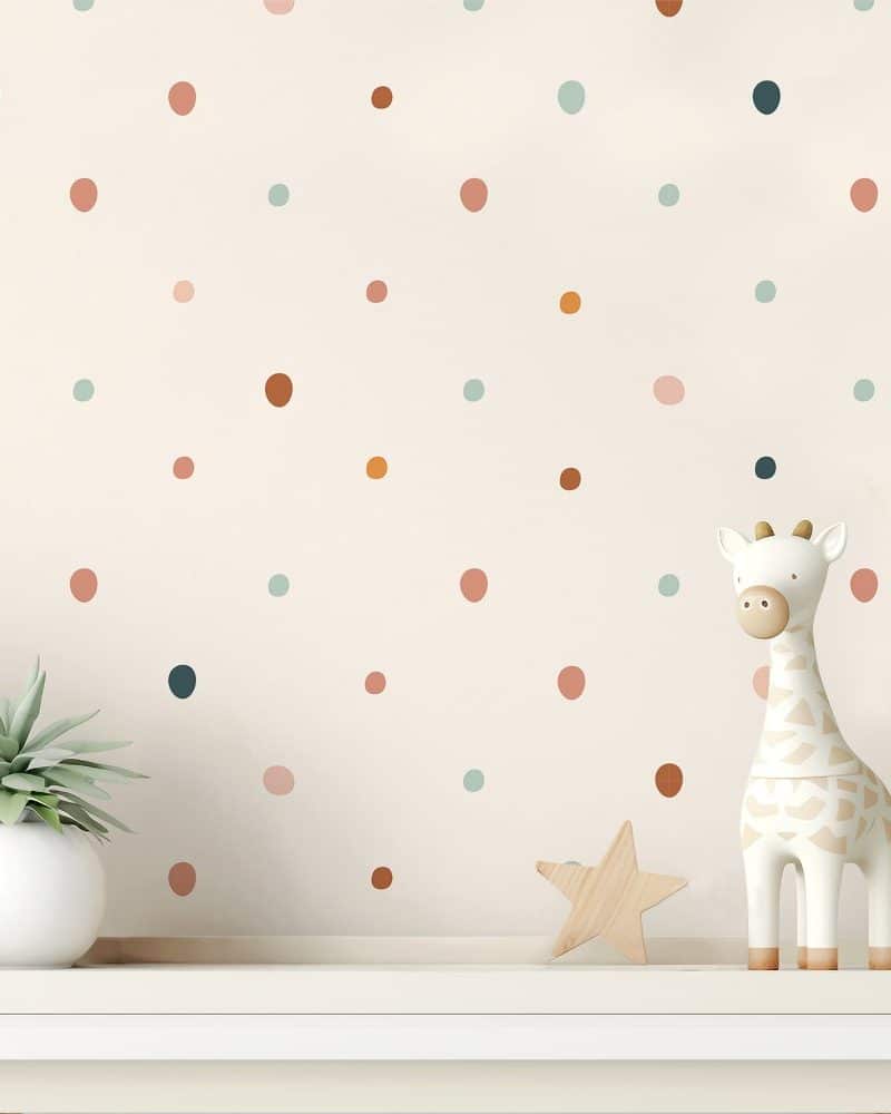 A shelf with a small potted plant, a wooden star, and a giraffe figurine against a wall with multicolored polka dots.