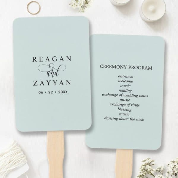 Two Light Blue Wedding Ceremony Programs Attached To Wooden Handles. One Program Displays The Names Reagan And Zayyan And The Wedding Date. The Other Lists The Ceremony Events.