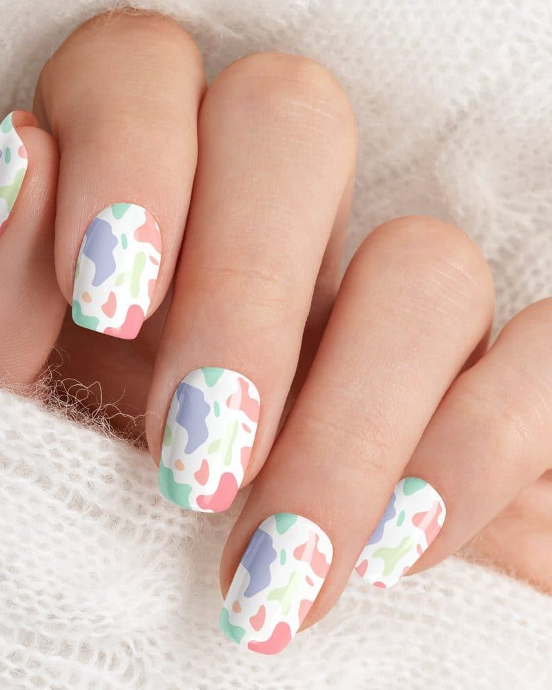 Closeup of a hand with pastel abstract nail art.