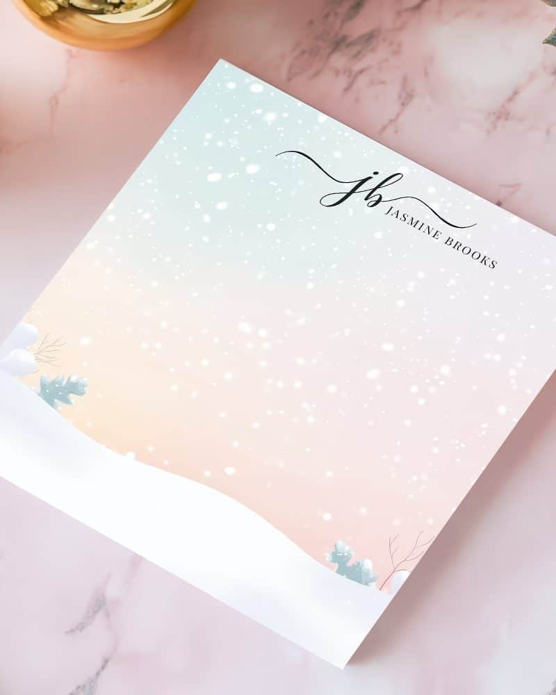 Winter-themed notepad with a pastel background, snowflakes, and a minimalist snowy landscape. The initials JB and Jasmine Brooks are printed at the top.
