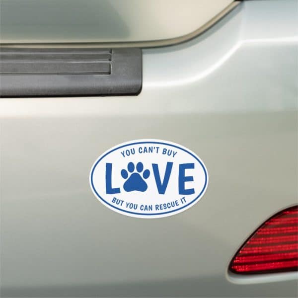 Oval Car Magnet With The Words You Can'T Buy Love, But You Can Rescue It. A Paw Print Is Centered In The Word Love.