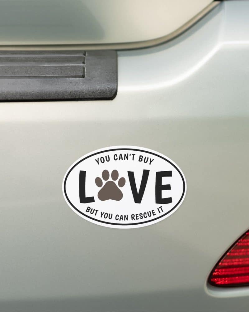 Oval car magnet with a paw print in the center of the word LOVE. Text reads You can't buy love, but you can rescue it.