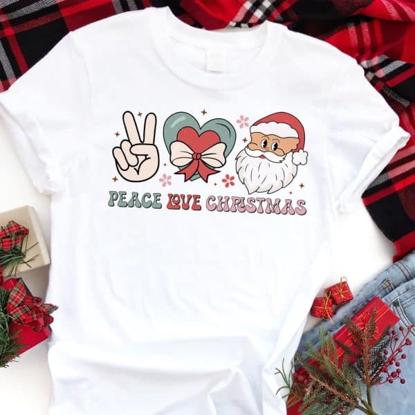White T-Shirt With A Peace Sign, Heart, Santa Face, And The Text Peace Love Christmas.