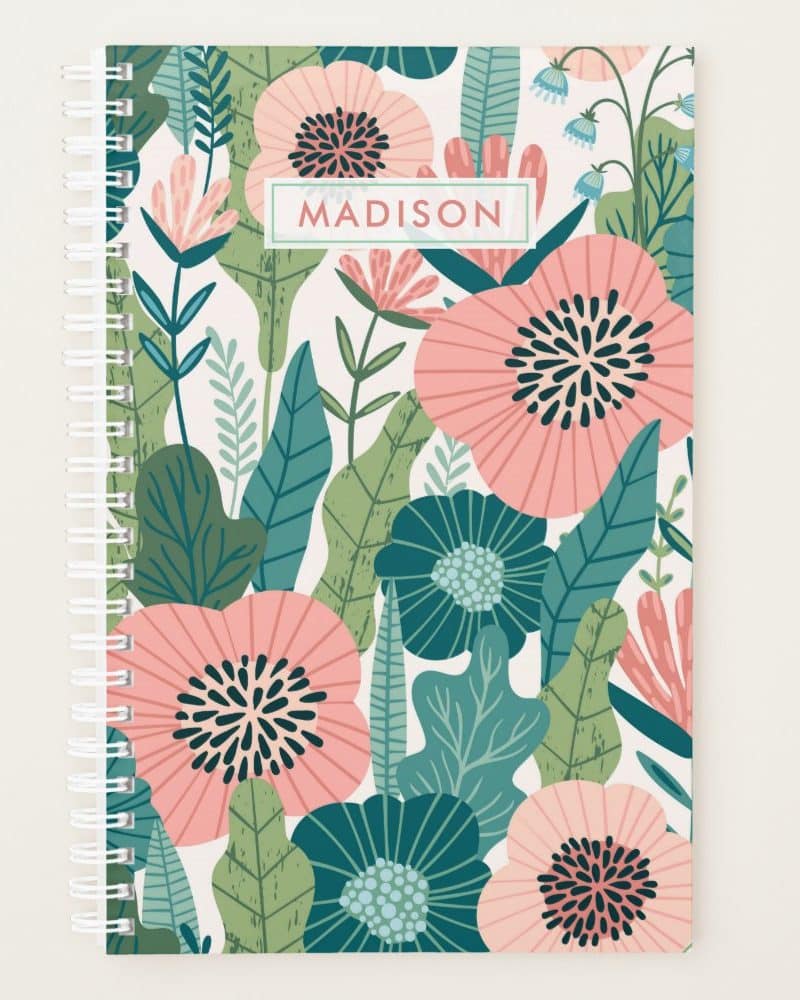 Spiral-bound notebook with a floral design featuring pink and teal flowers and leaves; the name Madison is printed on the cover.