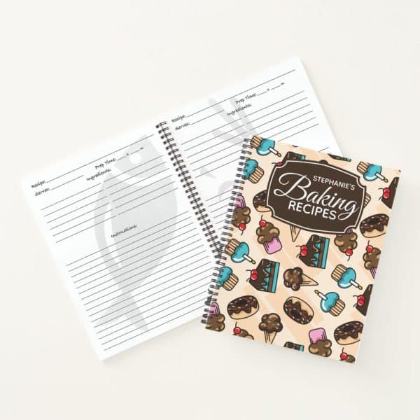 Spiral-Bound Baking Recipe Book With A Light Beige Cover Featuring Illustrated Cupcakes, Ice Cream Cones, And Cakes. The Book Is Titled Stephanies Baking Recipes.
