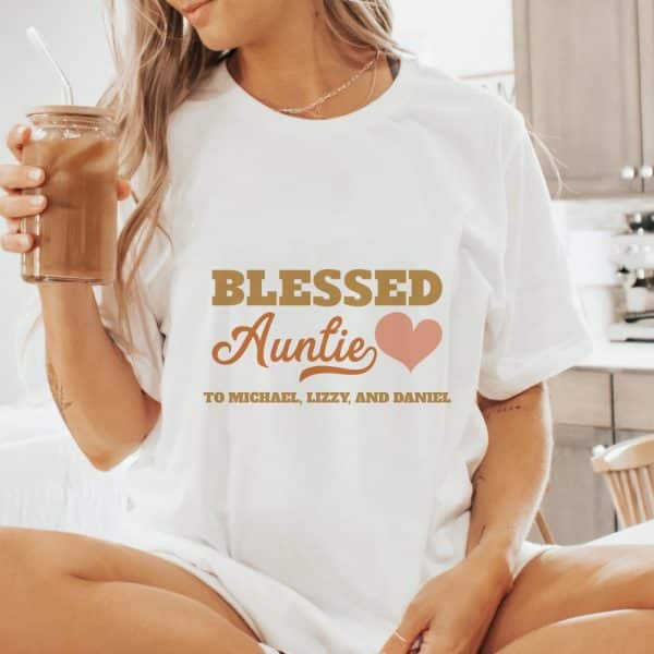 Woman Wearing A White T-Shirt That Says Blessed Auntie With A Heart And The Names Michael, Lizzy, And Daniel.