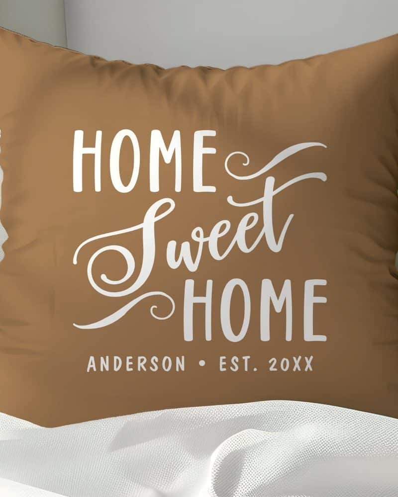 Brown pillow with white text reading Home Sweet Home and Anderson Est. 20XX.