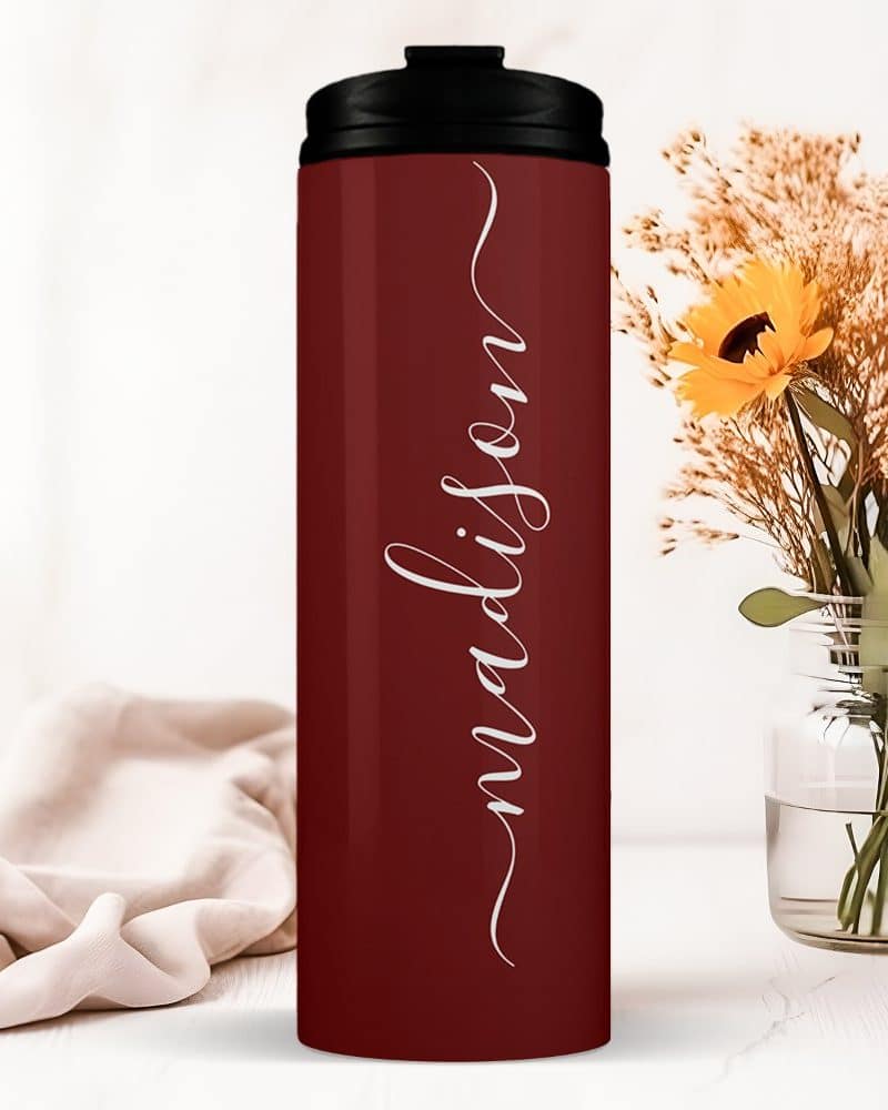 Burgundy travel tumbler with the name Madison in a script font.