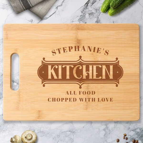 Personalized Bamboo Cutting Board With The Words Stephanie'S Kitchen And All Food Chopped With Love Engraved On It.