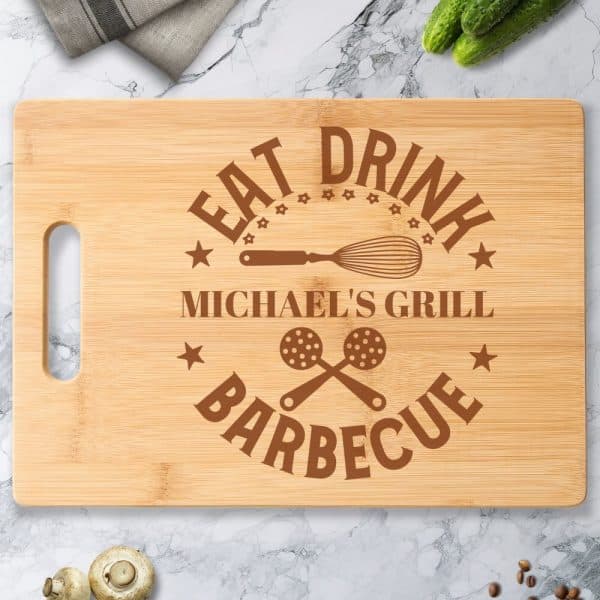 Personalized Bamboo Cutting Board With The Words Eat Drink Michael'S Grill Barbecue And Cooking Utensil Images.
